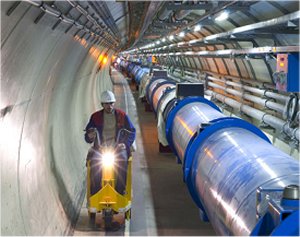Rys.2. Po lewej stronie przedstawiony jest plan LHC w CERN. Czerwona krzywa pokazuje ulokowany 100 m pod ziemią tunel o długości prawie 27 km. W tunelu tym umieszczone są dipole (zdjęcie po prawej stronie), w których bardzo silne, zmienne pole elektryczne przyspiesza protony lub jony ołowiu w jedną i drugą stronę oraz potężne pole magnetyczne utrzymujące zakrzywioną wiązkę cząstek wewnątrz pierścienia.